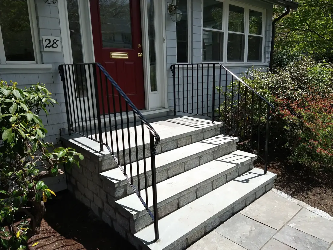 Black iron handrail on bluestone entry steps