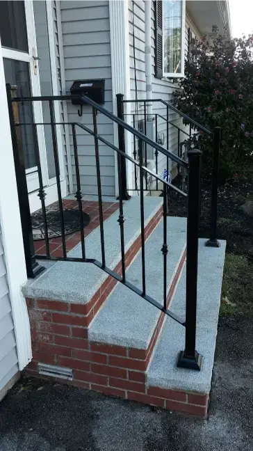 Black iron handrail on a brick stoop