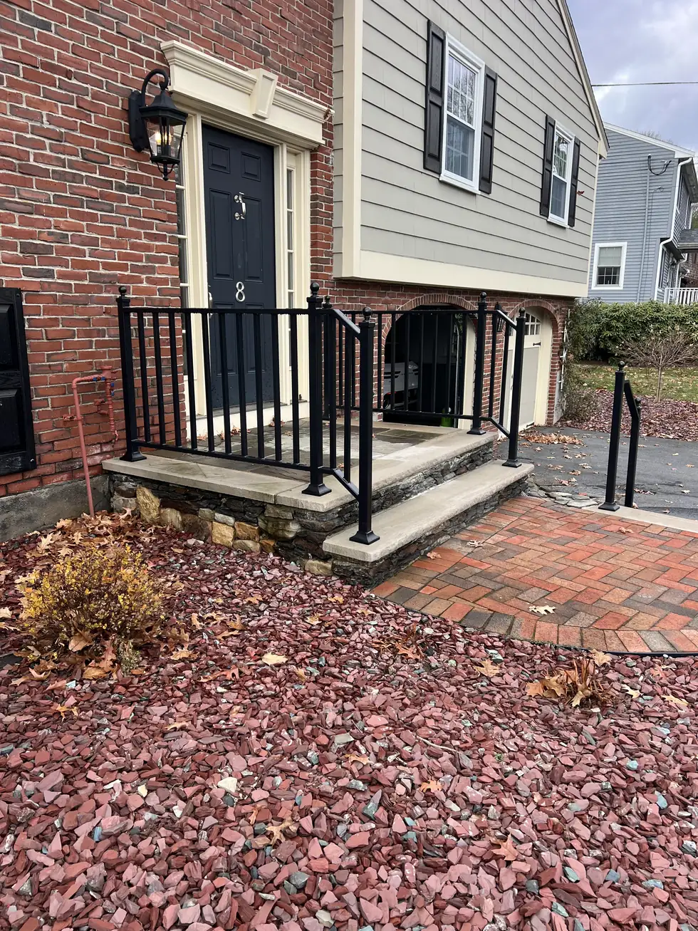 Black picket railing on brick front steps