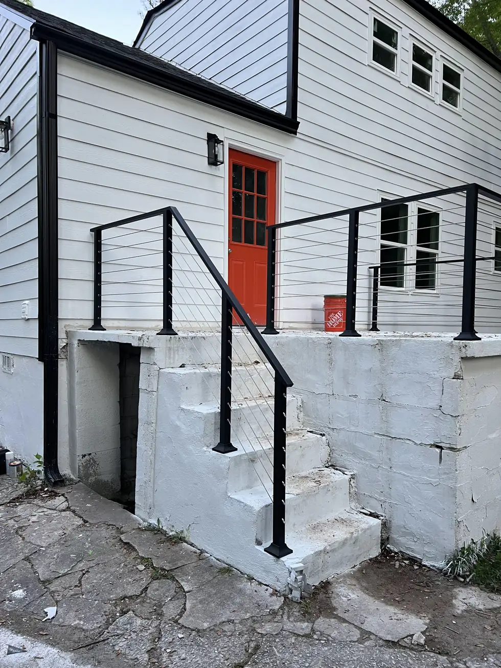Cable railing on front entry steps at a red door