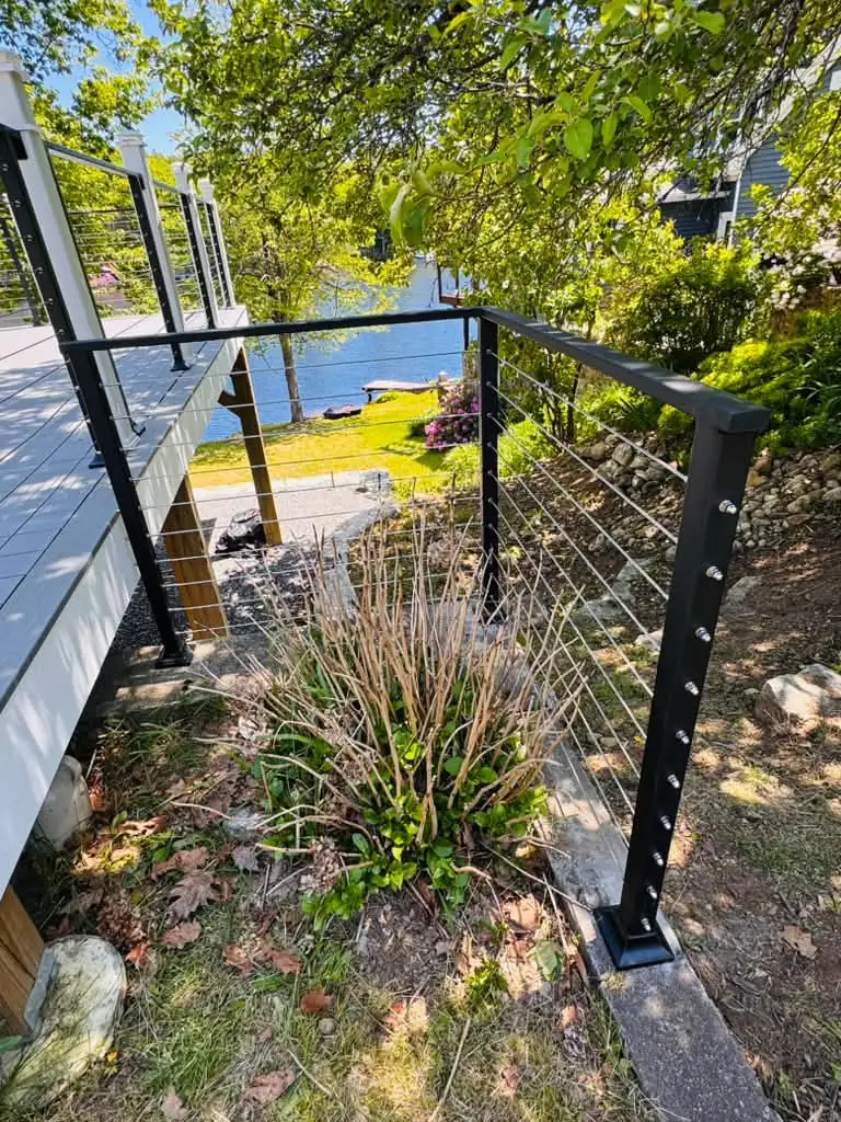 Cable railing on a lake view deck beside a planted garden