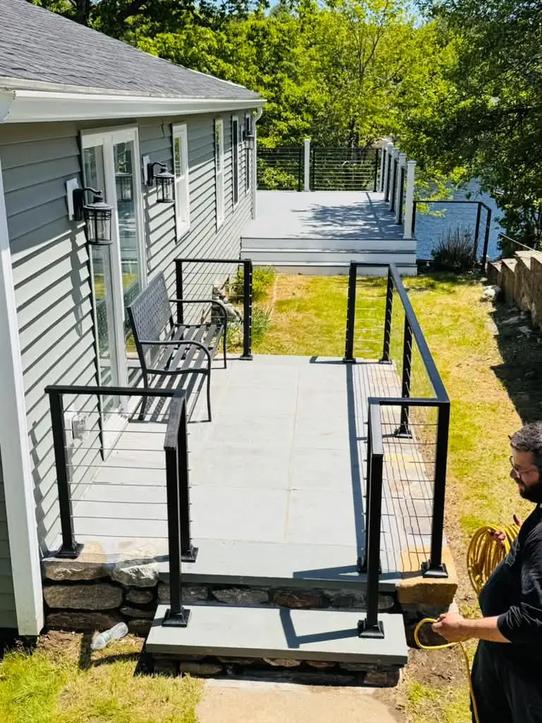 Falcons Iron Design crew installing a lakeside patio cable railing