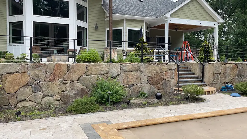 Cable railing around the perimeter of a stone wall patio