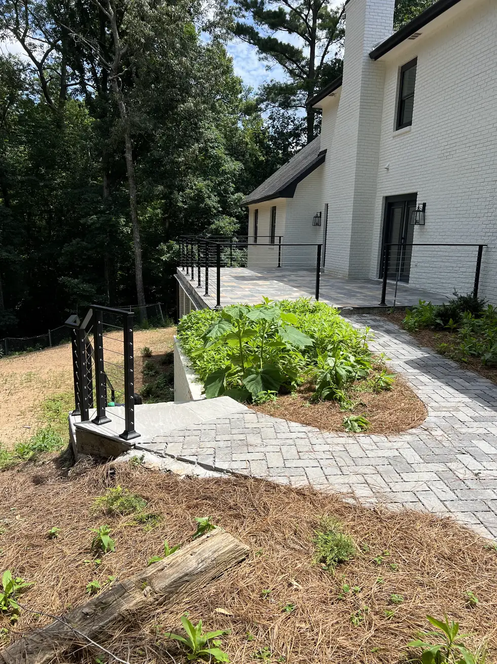 Cable railing along a sloped walkway beside a brick home