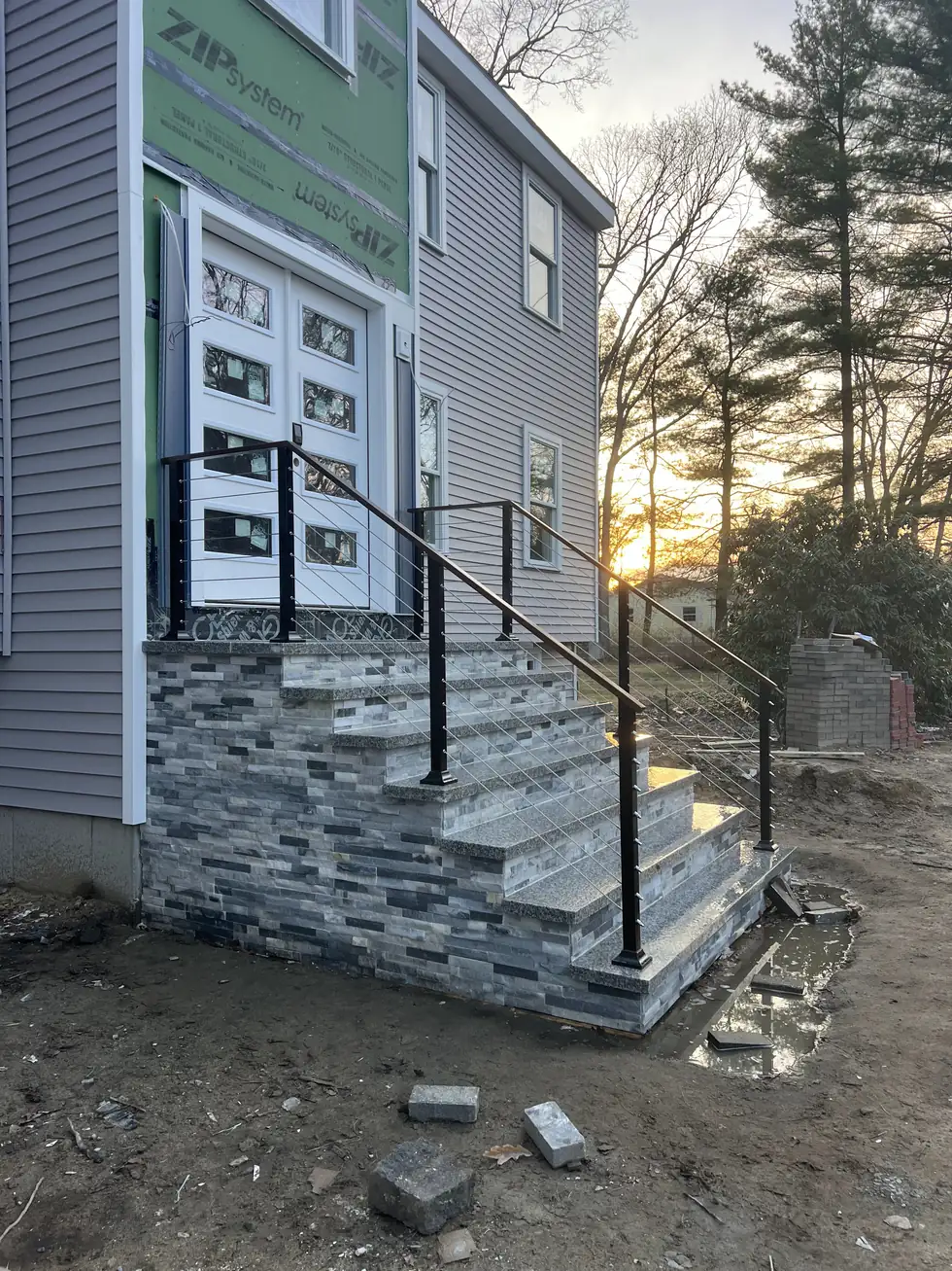 Cable railing with a wood handrail on new stacked stone entry steps