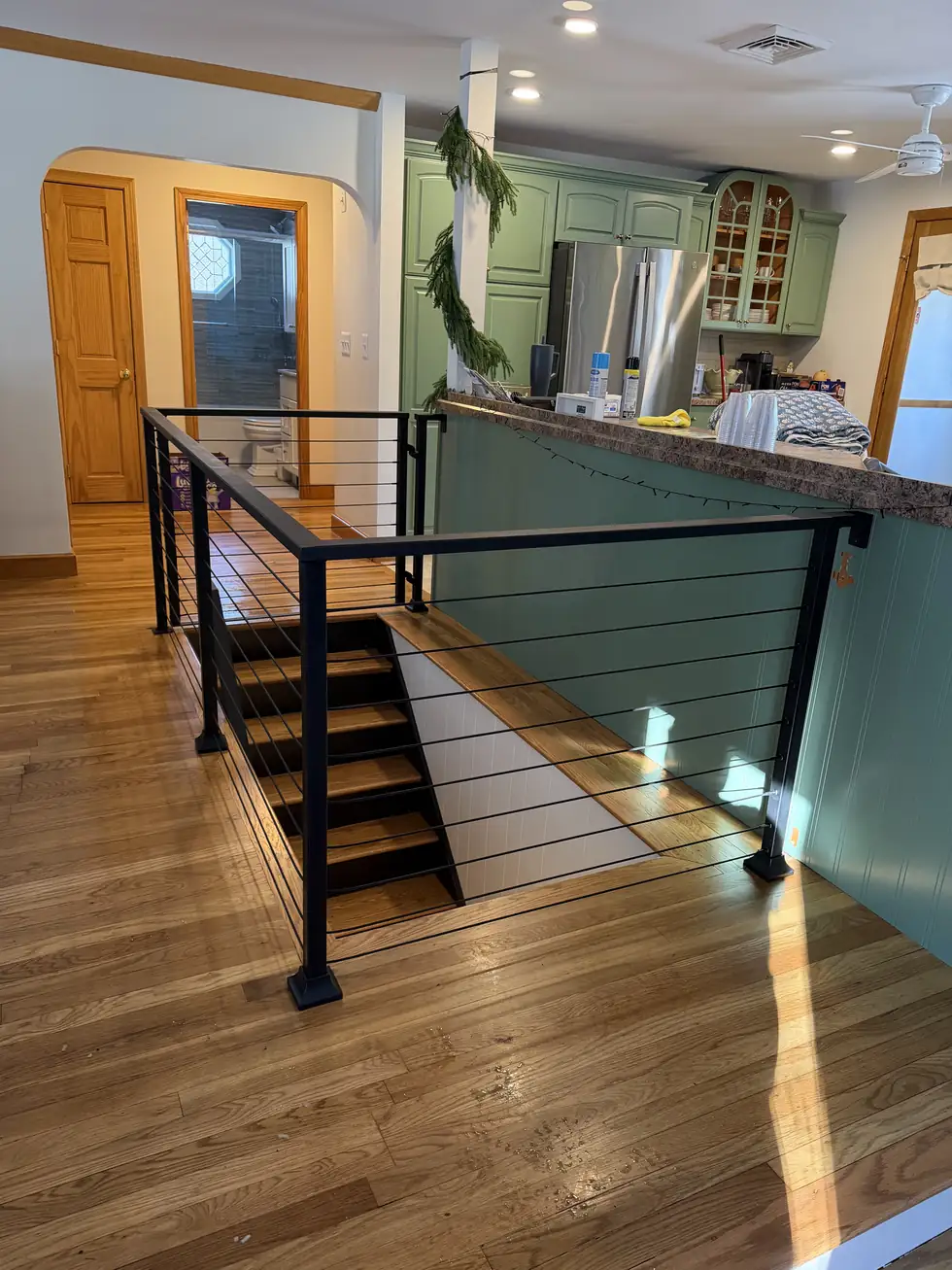Interior cable railing at kitchen level over hardwood flooring