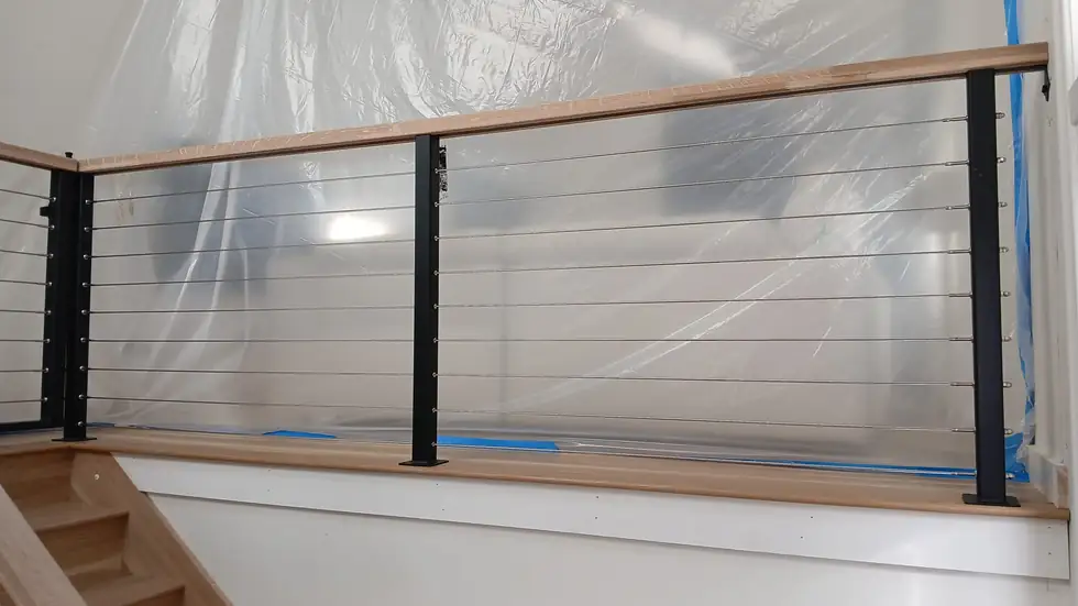 Detail of a wood top rail over an interior cable railing