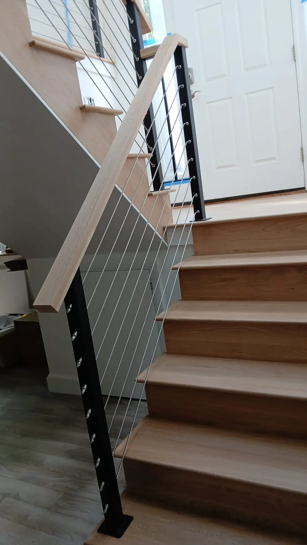 Interior entry stair cable railing with a wood handrail
