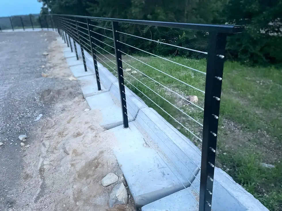 Long cable railing along a concrete retaining wall at a driveway