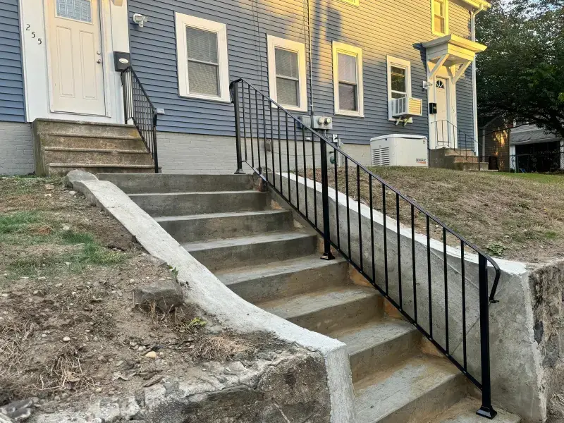 Steel handrail on driveway stairs at a multi-family home
