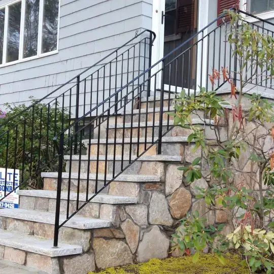 Long stair railing along stone retaining wall steps