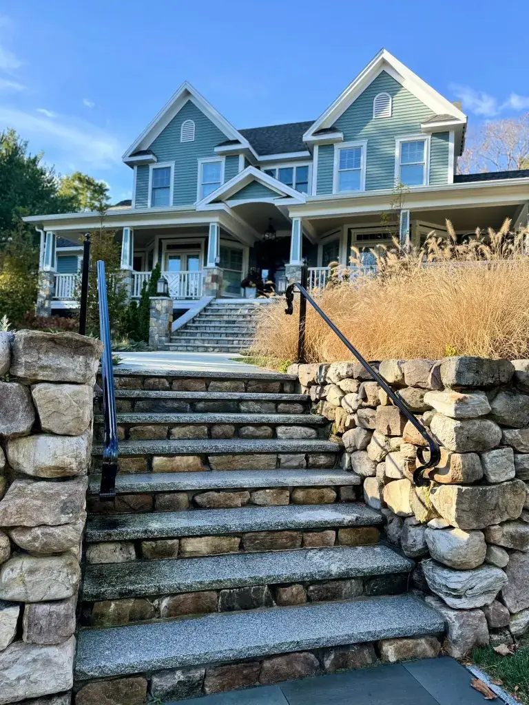 Long stone staircase with black iron handrail