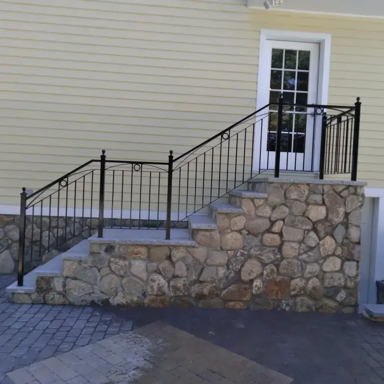 Ornamental iron railing on fieldstone front steps