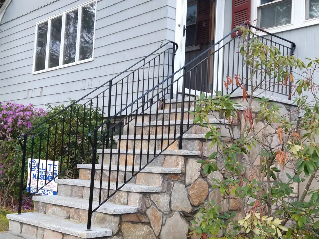 Ornamental iron railing installed on stone entry steps