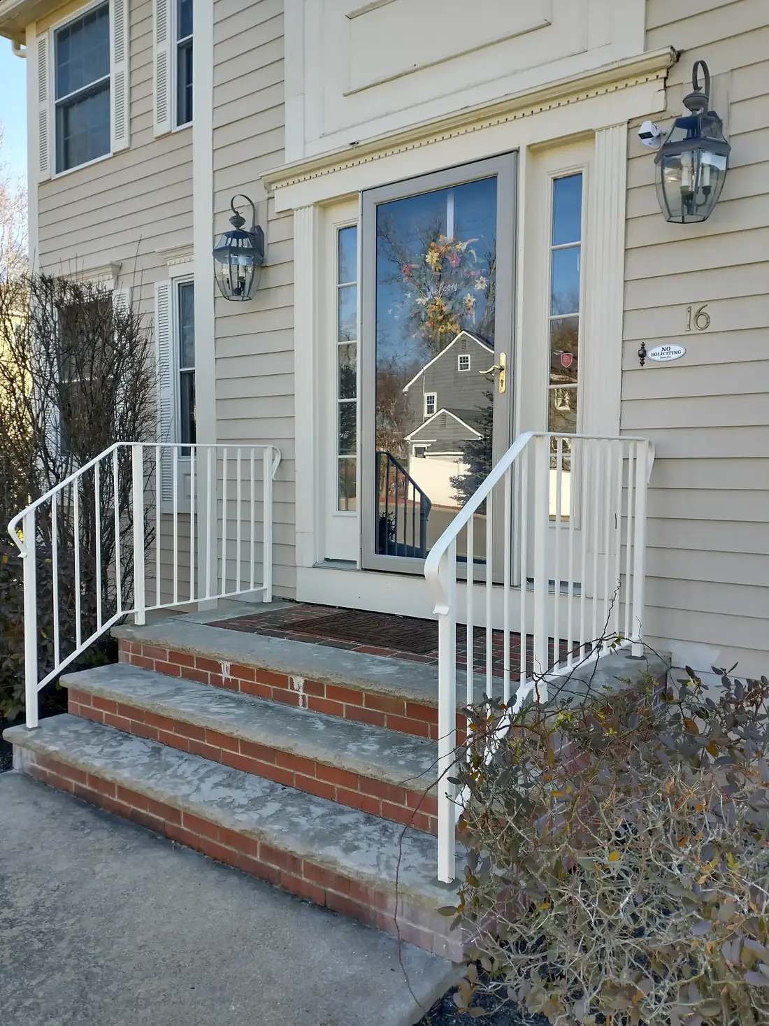 Steel handrail at a porch entry with brick steps