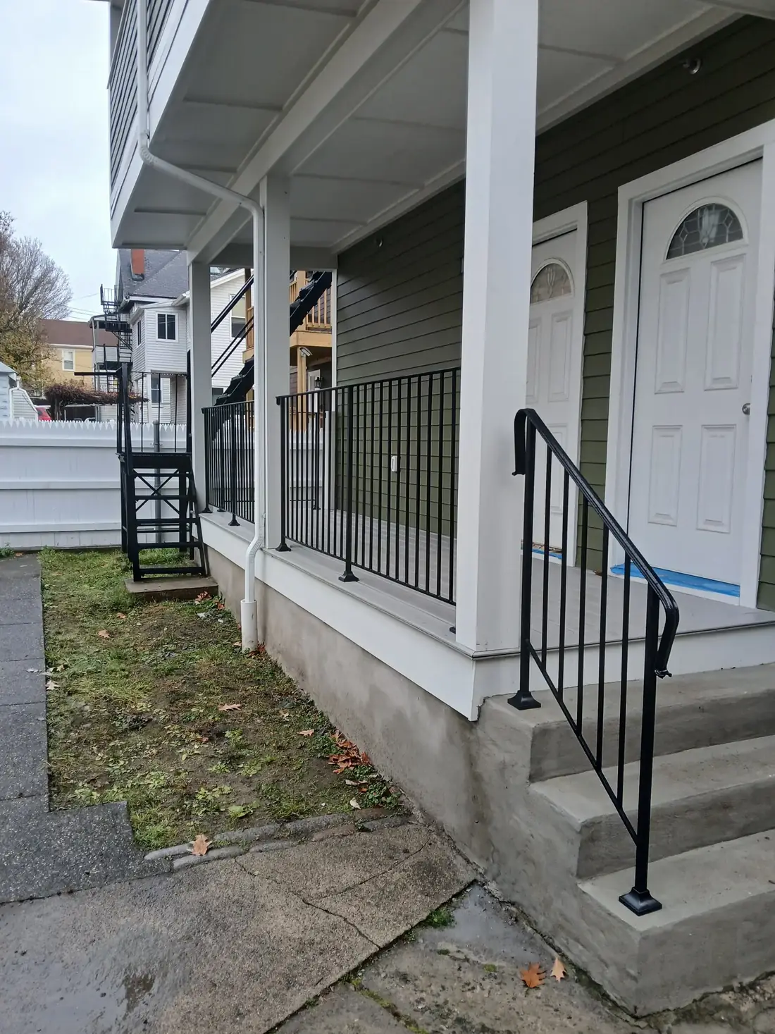 Steel porch post railing at a white entry door
