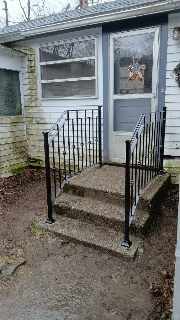 Simple black steel handrail on concrete entry steps