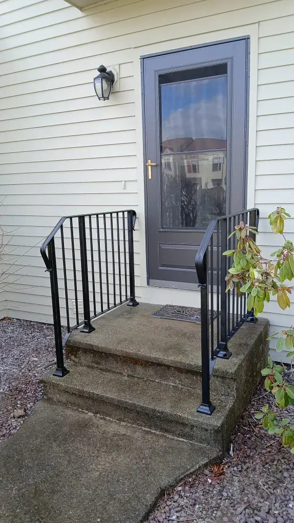 Single post iron handrail at small entry steps