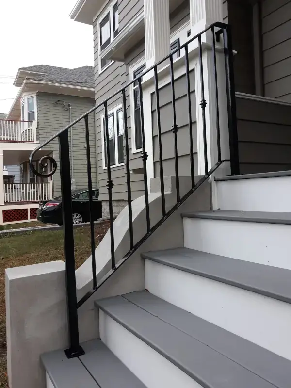 Tall steel stair railing at a side entrance deck