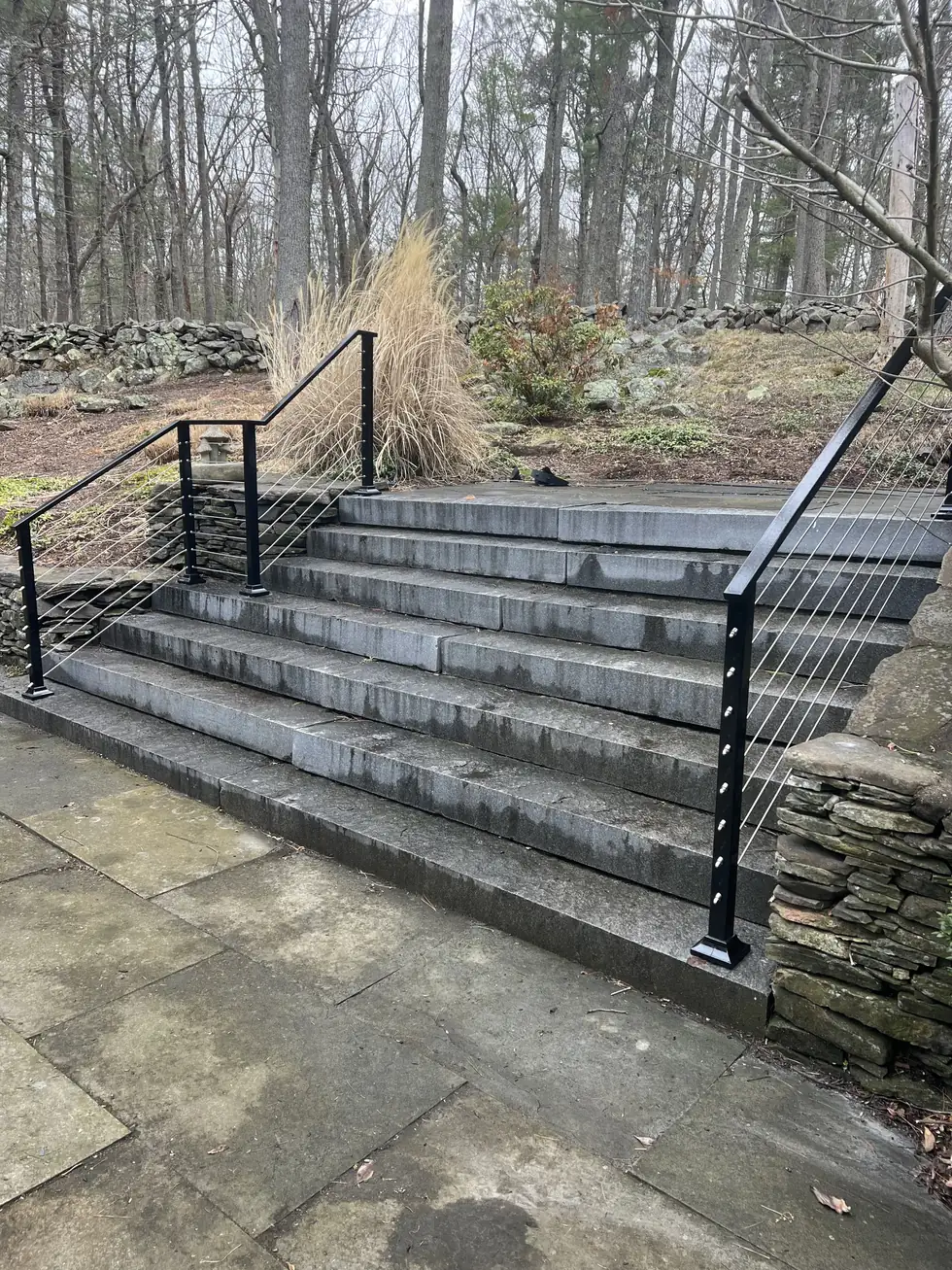 Long cable railing run along a wide stone staircase