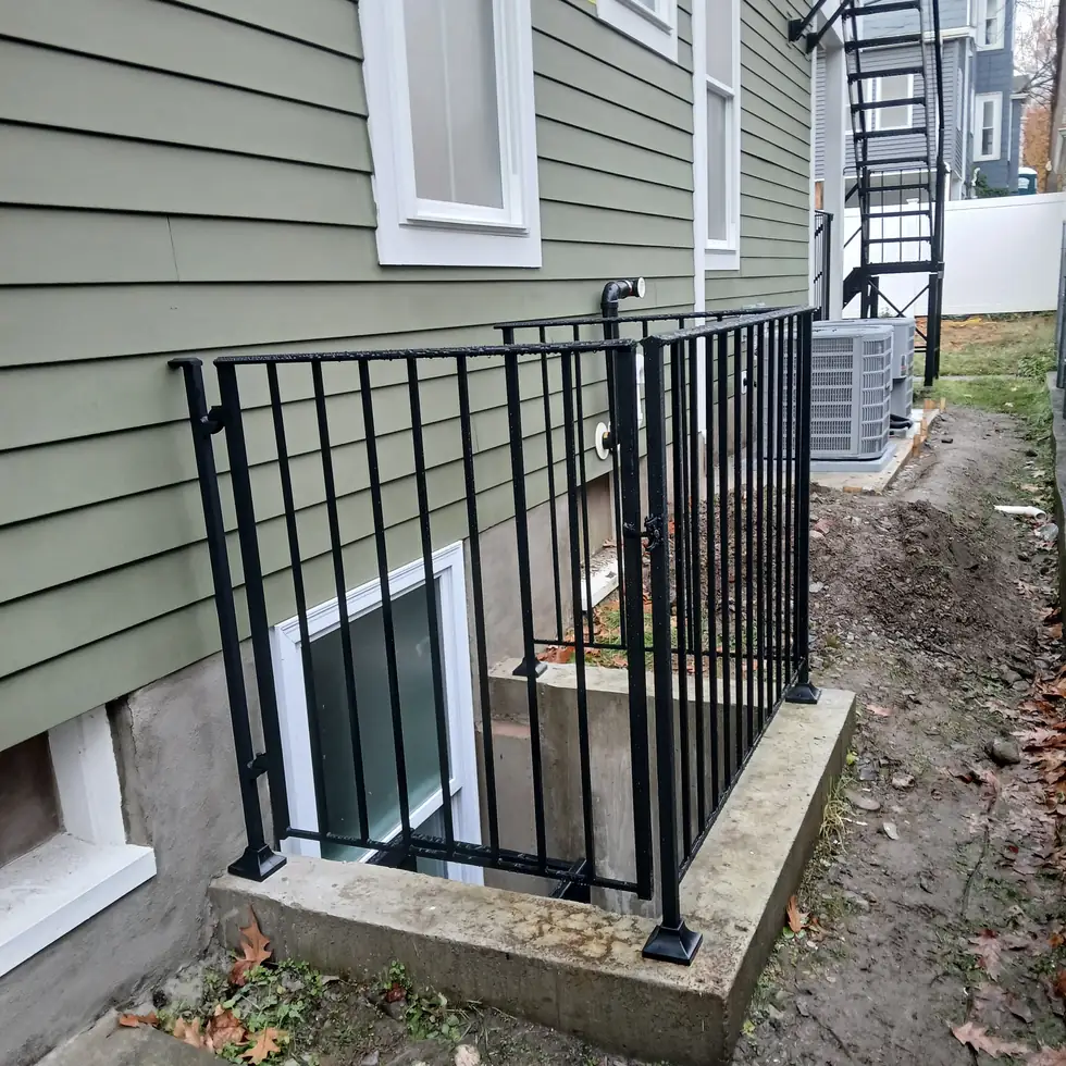 Custom iron walk gate with latch built into a side yard guardrail