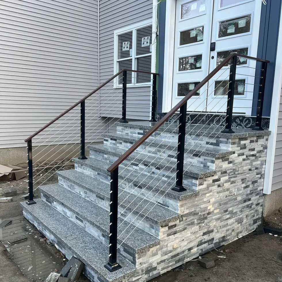 Stainless cable railing with a bronze handrail on stacked stone entry steps