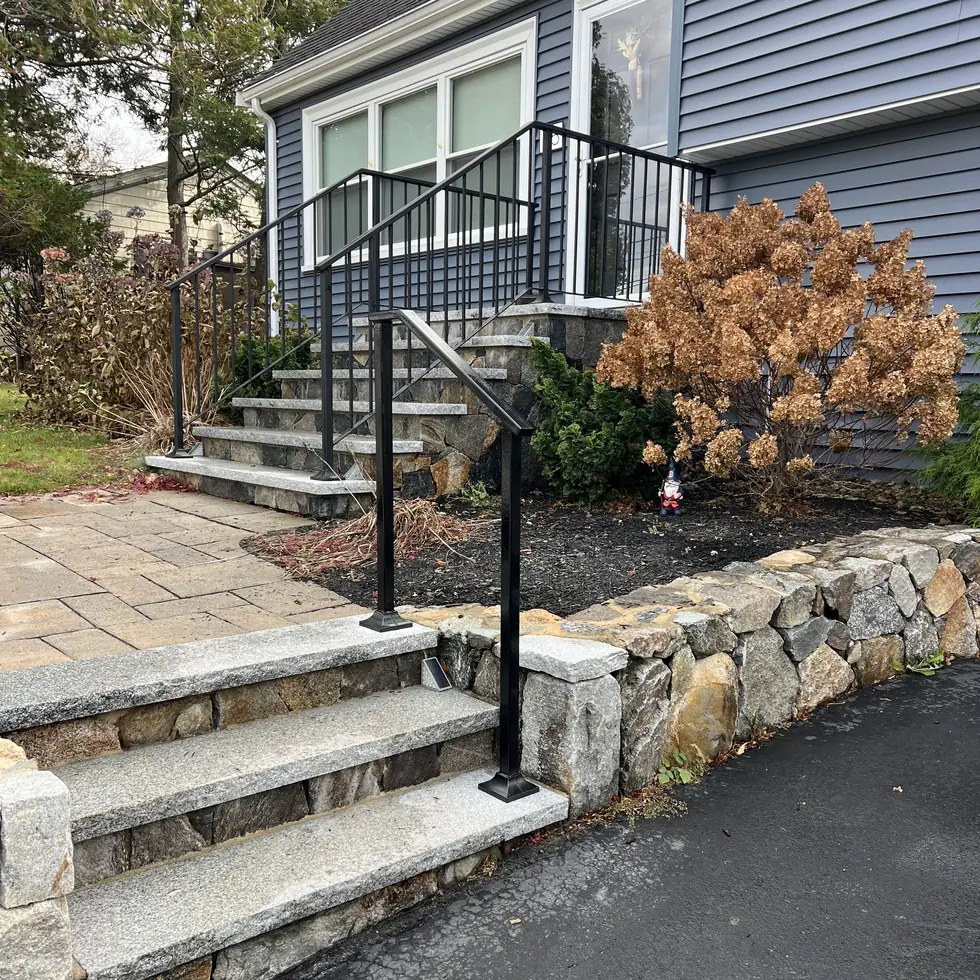 Black steel stair railing installed on granite front entry steps in Florida